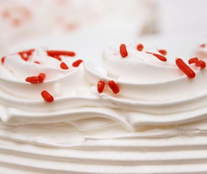 White frosting contrasts well with this bright red cake